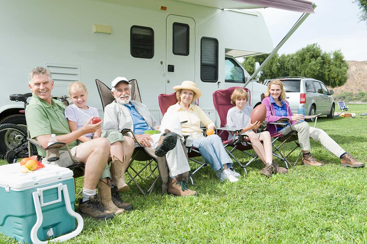 family sitting in chair in front of RV